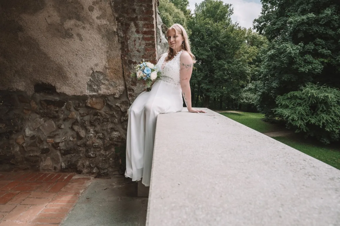 Poročna fotografija mladoporočencev; ujet pristen trenutek z naravno svetlobo in umirjeno kompozicijo v dokumentarnem slogu.